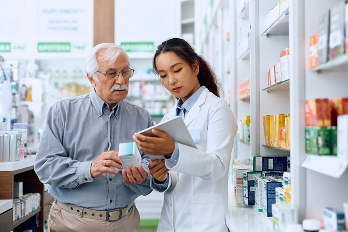 A pharmacist talking with an eldery man about his medication